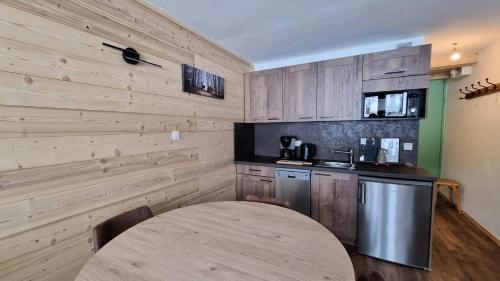 - une cuisine avec des murs en bois et une table dans une chambre dans l'établissement Résidence Le France - Résidence LE FRANCE N°939 MAE-5421, à La Plagne Tarentaise