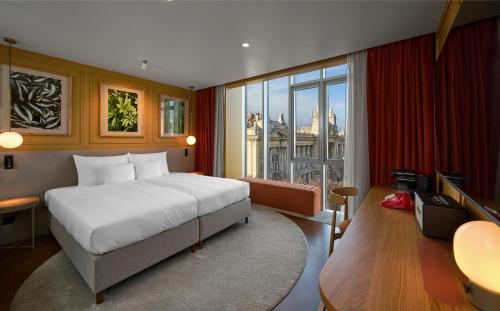 a bedroom with a large bed and a large window at Verno House Budapest, Vignette Collection by IHG in Budapest