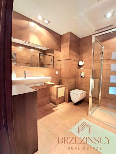 een badkamer met een toilet, een wastafel en een douche bij Apartament Blue Waves Wisełka in Wisełka