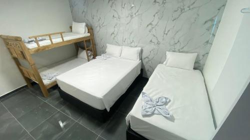 a small room with two beds with a butterfly on them at Hotel Mall plaza in Santa Marta