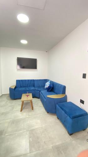 a living room with a blue couch and a table at Hotel Mall plaza in Santa Marta