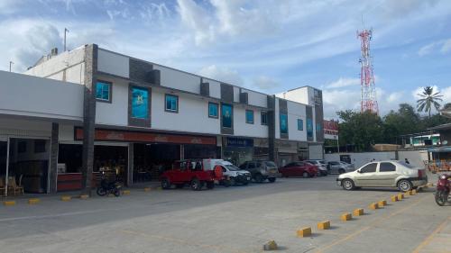 a building with cars parked in a parking lot at Hotel Mall plaza in Santa Marta