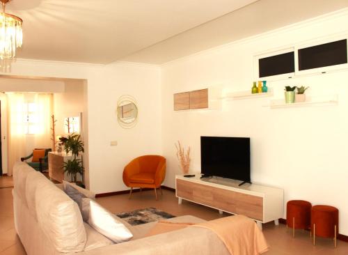 a living room with a couch and a flat screen tv at Madeira Home Spacious Accommodation in Funchal