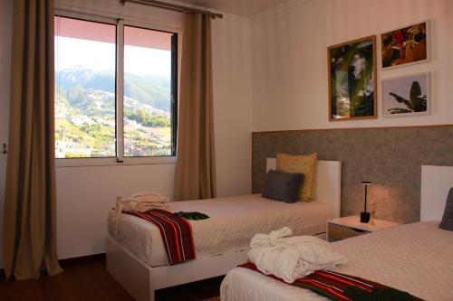 a hotel room with two beds and a window at Madeira Home Spacious Accommodation in Funchal