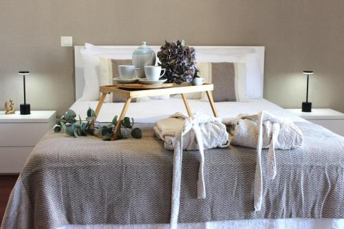 a bed with a tray with a table on it at Madeira Home Spacious Accommodation in Funchal