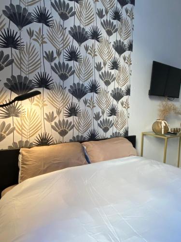 une chambre avec un lit avec un papier peint bleu et blanc dans l'établissement Le Cabanon de la Noue, à Conflans-Sainte-Honorine