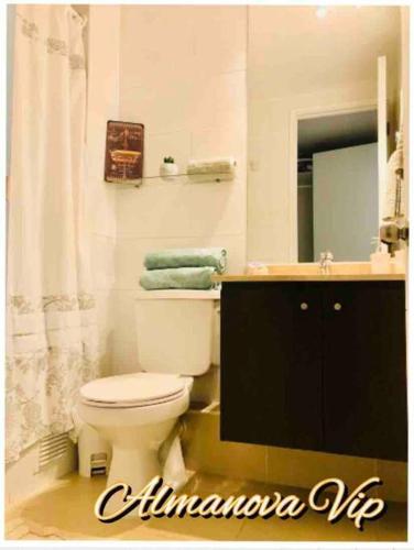 a bathroom with a toilet and a sink and a mirror at Almanova Sunset in Antofagasta
