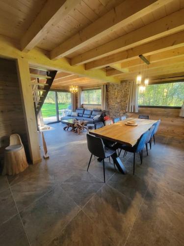 - un grand salon avec une table et des chaises en bois dans l'établissement Chalet à louer, Spa, sauna, billard, gerardmer, à Gérardmer