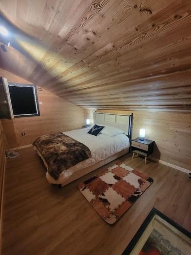 - une chambre avec un lit et une télévision dans une cabane en rondins dans l'établissement Chalet à louer, Spa, sauna, billard, gerardmer, à Gérardmer
