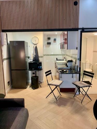 Il comprend un salon avec des chaises et une cuisine équipée d'un réfrigérateur. dans l'établissement 