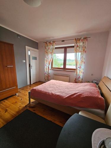a bedroom with a red bed and a window at Jurajska Bajka in Przybynów