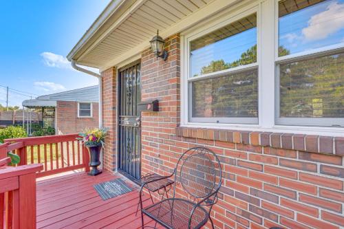 a brick house with a chair on a deck at 4 Mi to Dtwn Home with Fenced Yard in Portsmouth! in Portsmouth