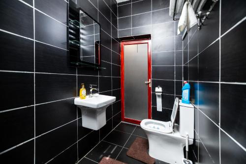 a bathroom with a white toilet and a sink at Stay with Peace on Spintex Road in Ablekuma