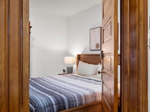 a small bedroom with a bed and a wooden door at Oakland, Pittsburgh !A Modern and Stylish Private Bedroom with Shared Bathroom in Pittsburgh