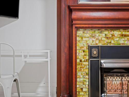 a fireplace in a room with a table and a chair at Oakland, Pittsburgh !A Modern and Stylish Private Bedroom with Shared Bathroom in Pittsburgh