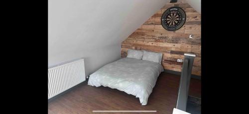 a bed in a room with a clock on the wall at The perfect stay, 2 bedroom, great location. in Stoke Golding