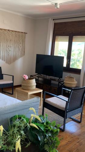 a living room with a couch and chairs and a flat screen tv at La Muga de Llívia in Llivia