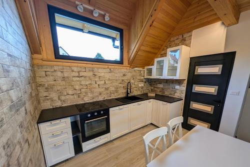 a small kitchen with a table and a window at Fuzine Lake Apartments in Fužine