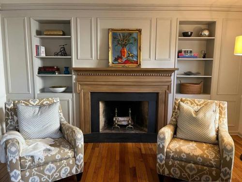 a living room with two chairs and a fireplace at Historic Wayne Street - close to the Stadium in South Bend