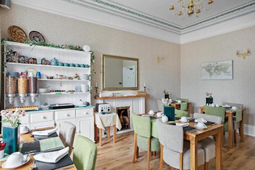 a dining room with tables and chairs and a fireplace at Kings Lodge in Torquay