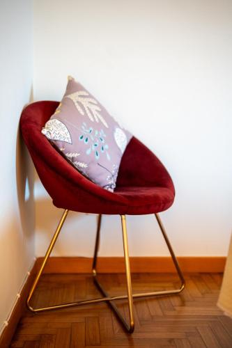 a red chair with a pillow on top of it at LHE Maison Almerici in Cesena