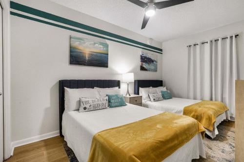 two beds in a room with white walls at Phoenix VIII 8904: Sand Shells and Sun in Orange Beach