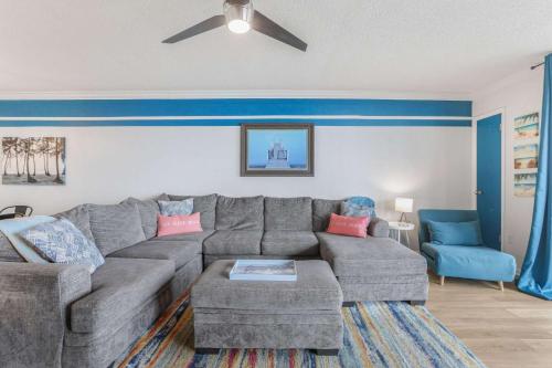 a living room with a gray couch and a blue wall at Phoenix VIII 8904: Sand Shells and Sun in Orange Beach