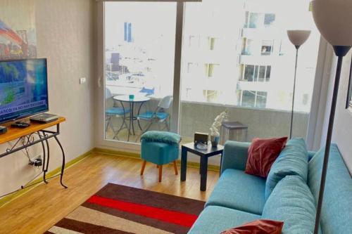 アントファガスタにあるAlmanova Sunriseの青いソファとテレビのあるリビングルーム