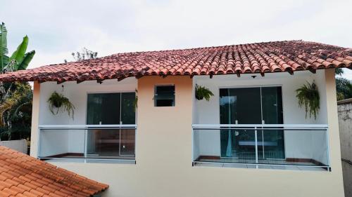 a white house with windows and a red roof at Pousada Coqueiro in Paraty