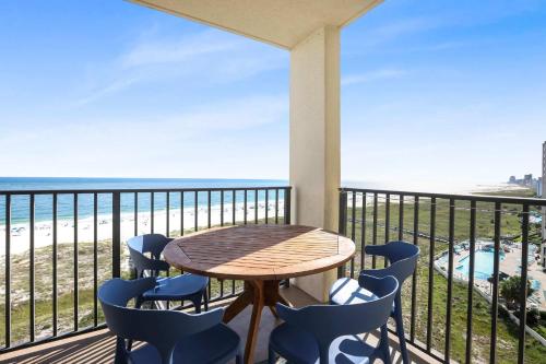 a table and chairs on a balcony with a view of the beach at Phoenix VIII 8904: Sand Shells and Sun in Orange Beach