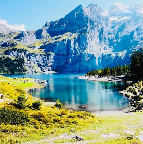 a body of water in front of a mountain at Cute & cozy oasis, private afternoon sun terrace in Kandersteg