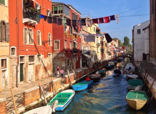 un grupo de barcos en un canal con edificios en Appartamento Ca' Marco Polo, en Venecia