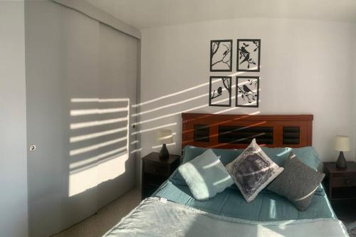 a bedroom with a bed with blue sheets and pillows at Hermoso Departamento en Los Angeles in Los Ángeles