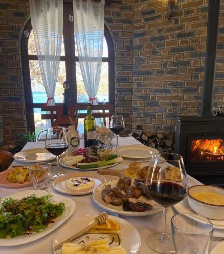 a table with plates of food and glasses of wine at Agora Farmhouse in Koman