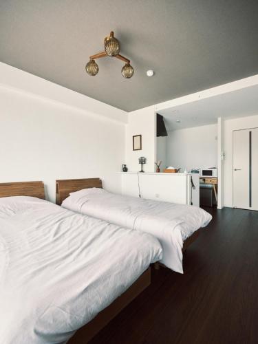 a bedroom with two beds and a ceiling fan at intro vetta 1003 Free parking in Kumamoto