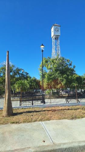 a clock tower in a park with a fence at Mi Refugio in San Fernando de Monte Cristi