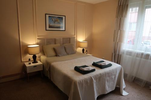 a bedroom with a bed with two towels on it at M2 Suite by Central Park in Kragujevac