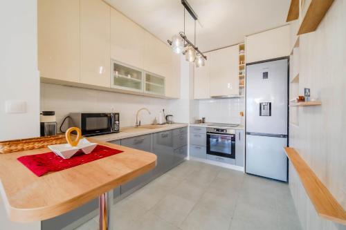 a kitchen with white cabinets and a wooden counter top at Apartment Saga With Terrace And Parking - Happy Rentals in Zagreb