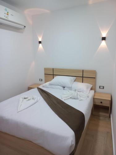 a bedroom with a large white bed with two lights at Malak Guest House in Cairo