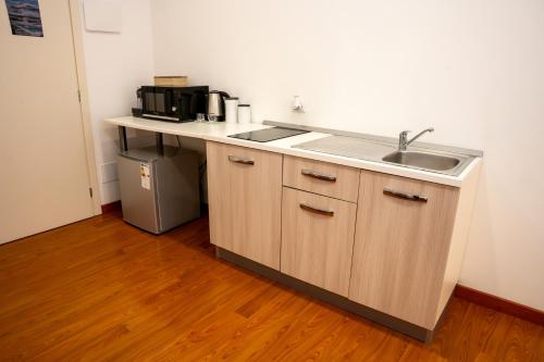a kitchen counter with a sink and a microwave at LHE Les Trois Merveilles in Cesena