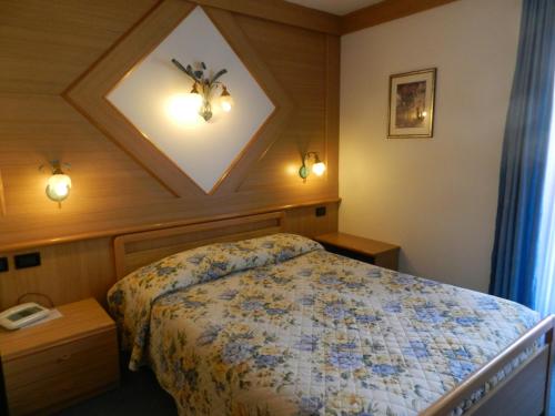 a bedroom with a bed in a room with a ceiling at Hotel Stella Alpina in Moena