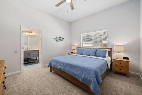 Un dormitorio con una cama con una colcha azul y una ventana. en Jax Beach Getaway 5 Minute Walk to the Waves, en Jacksonville Beach