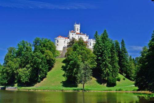 a castle on top of a hill with trees at Twin Oasis Retreat with Pool & Spa - Happy Rentals in Biškupec Zelinski