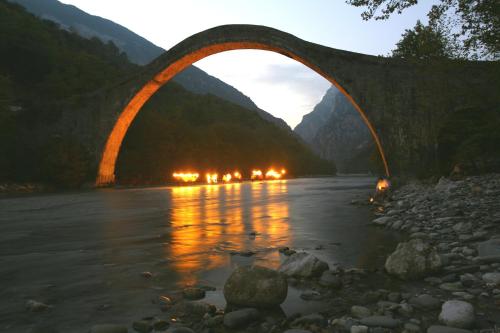 a bridge over a river with lights on at Frasta's Rose in Plaka