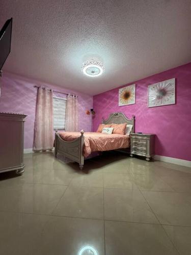 a bedroom with a bed in a purple wall at Beautiful and comfy home! in Seffner