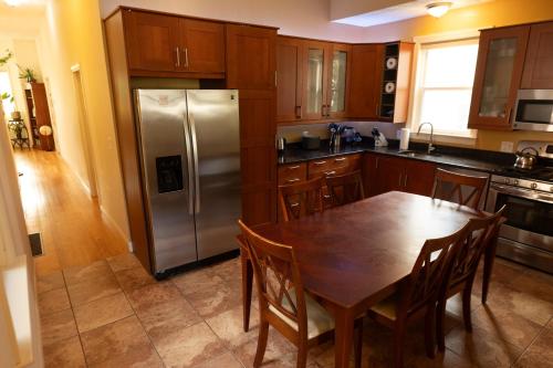 a kitchen with a table and a stainless steel refrigerator at 2 bedroom Boston condo in Jamaica Plain with parking in Boston