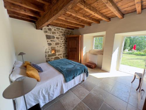 une chambre avec un lit, une table et une fenêtre dans l'établissement Maison La Chanette, Vue Montagne, Proche Lac et Randonnées, Grand Jardin, Brasero, Calme, Charme, 10-12 pers, Idéal Familles, à Les Chanets