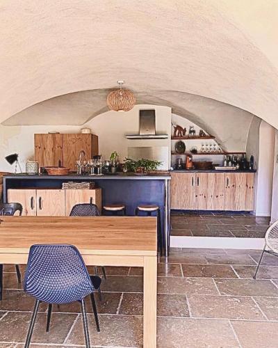 une cuisine avec une table et des chaises en bois dans l'établissement Maison La Chanette, Vue Montagne, Proche Lac et Randonnées, Grand Jardin, Brasero, Calme, Charme, 10-12 pers, Idéal Familles, à Les Chanets