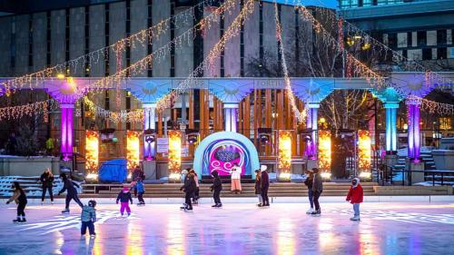 an ice skating rink in front of a building with christmas lights at Staybridge Suites - Calgary Airport by IHG in Calgary