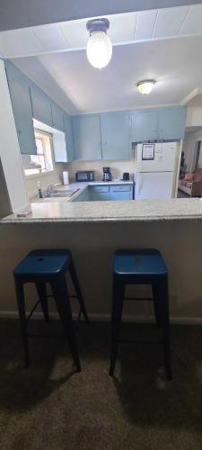 a kitchen with a counter and two blue stools at 15mins to Downtown- Adorable on Taylor Both Units in West Columbia